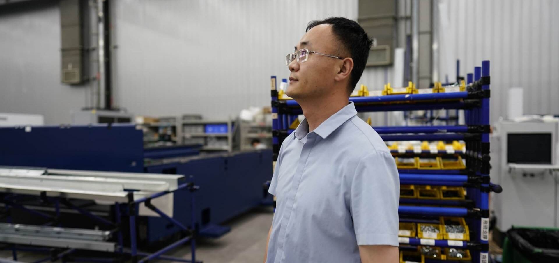 Sean Lin blickt zufrieden in die Produktionshalle.